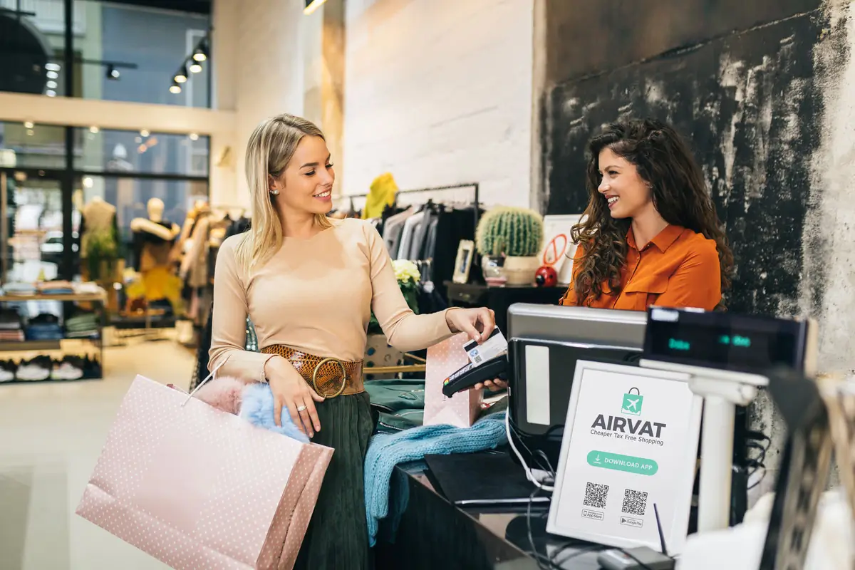 Happy tourist making a vat free purchase in a London store displaying Airvat logo