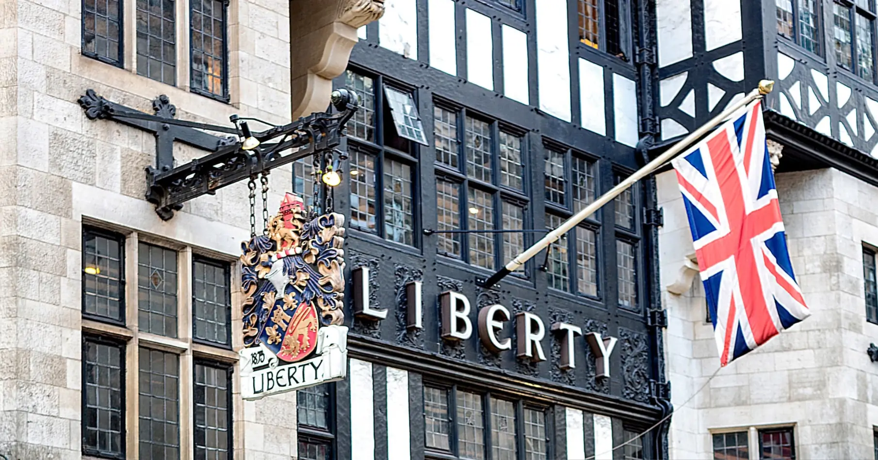 Iconic luxury shopping centre in London with a British flag flying above the store front